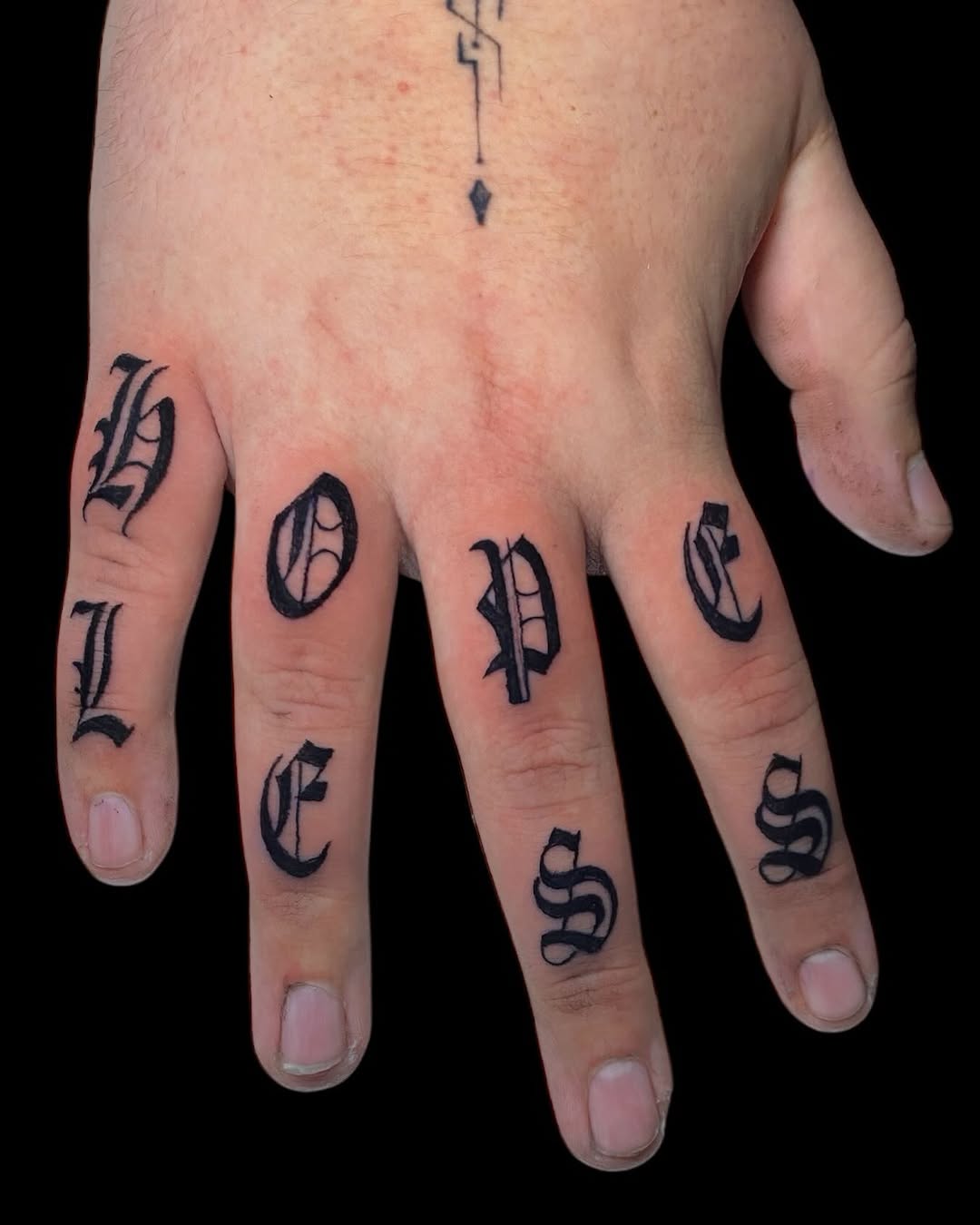 Bold gothic lettering across fingers spelling hopeless.