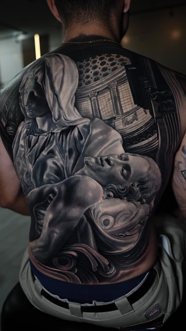 Monumental grayscale Pietà-inspired back piece, dramatic