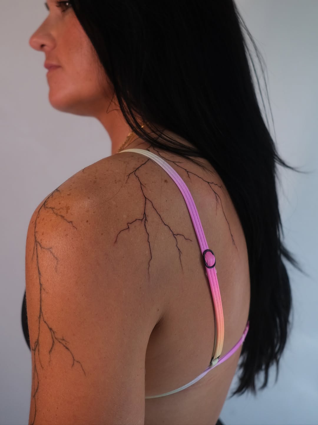 Crackled vein-like fine-line blackwork across shoulder