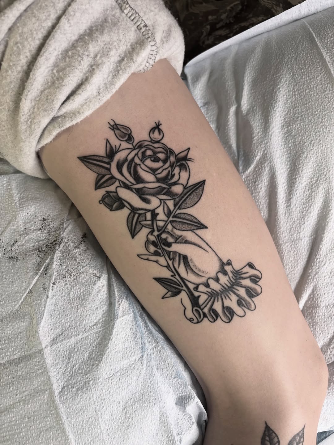 Bold outlined rose held by a delicate hand.