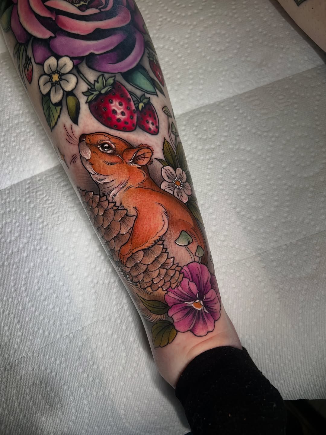 Vibrant neo-traditional sleeve segment with orange squirrel among berries and pinecones
