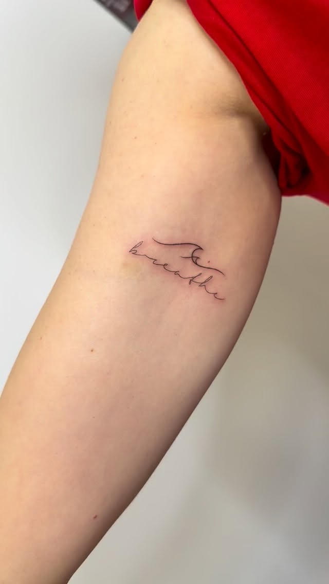 Whisper-thin cursive 'breathe' with subtle wave flourish.