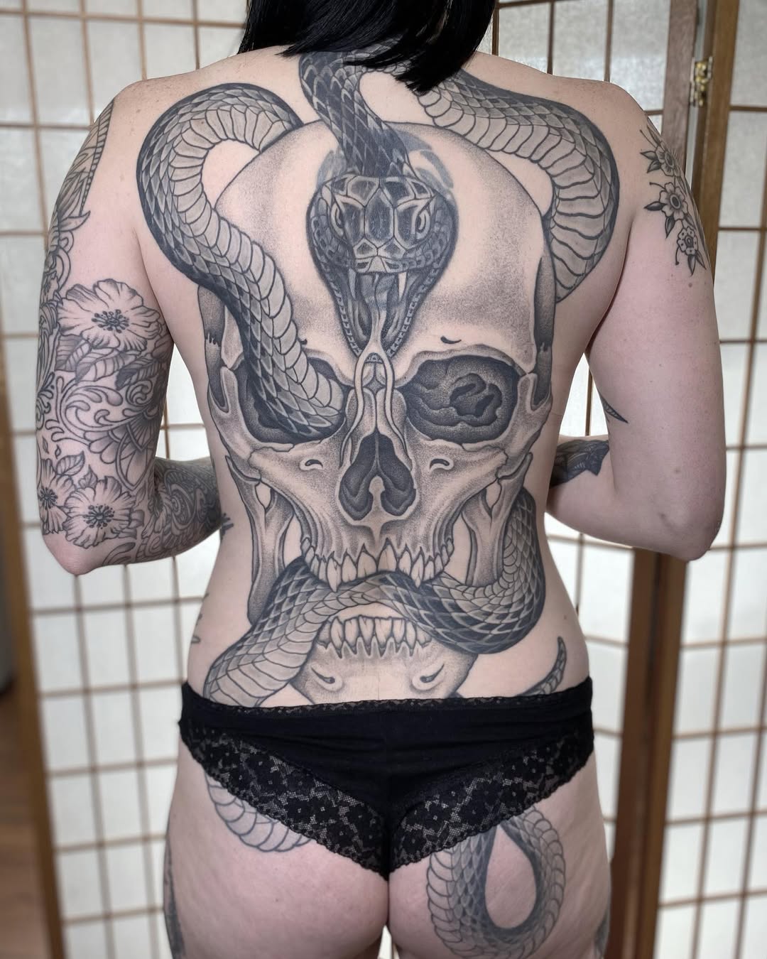 Monumental black-and-gray skull with a coiling serpent backpiece.