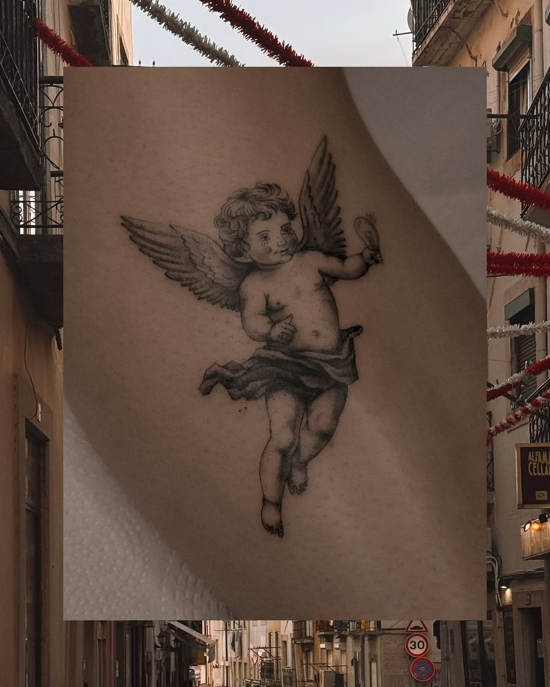 Delicate cherub with fluttering wings in fine-line blackwork.