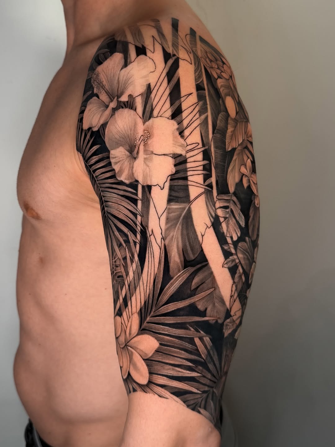 Dramatic tropical botanical sleeve with hibiscus motifs in blackwork.