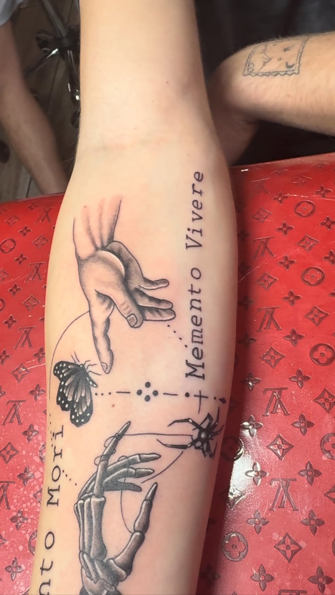 Melancholic symbolic forearm tattoo with butterfly and skeletal hands