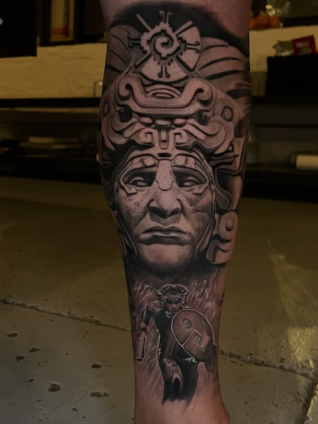 Monumental black-and-gray mask with ornate helmet motif