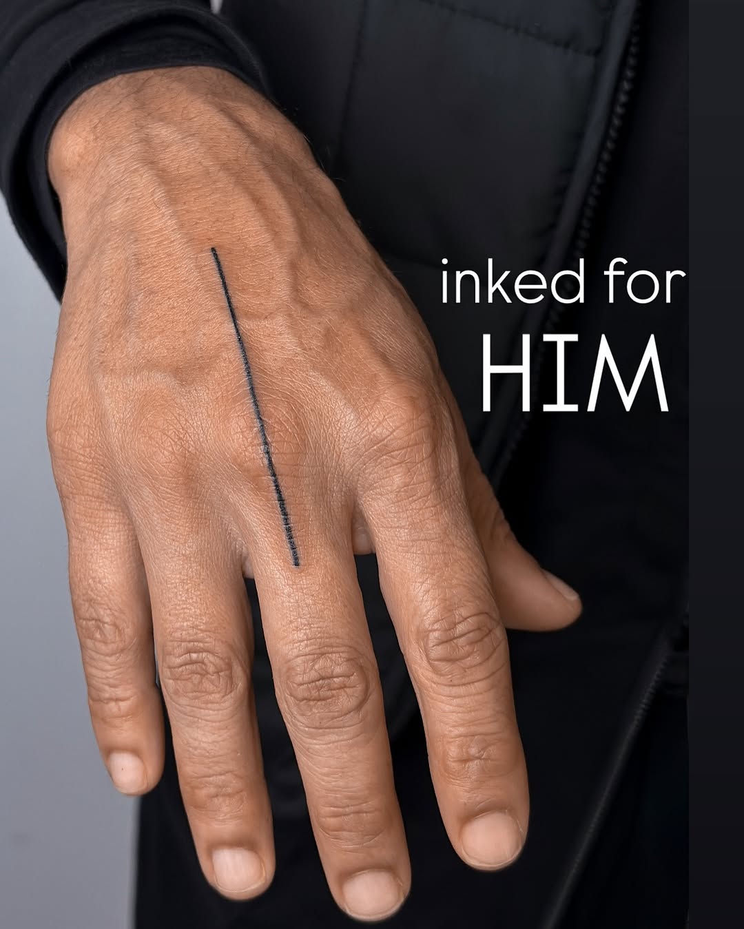 Minimalist single-line tattoo running along the back of the hand.