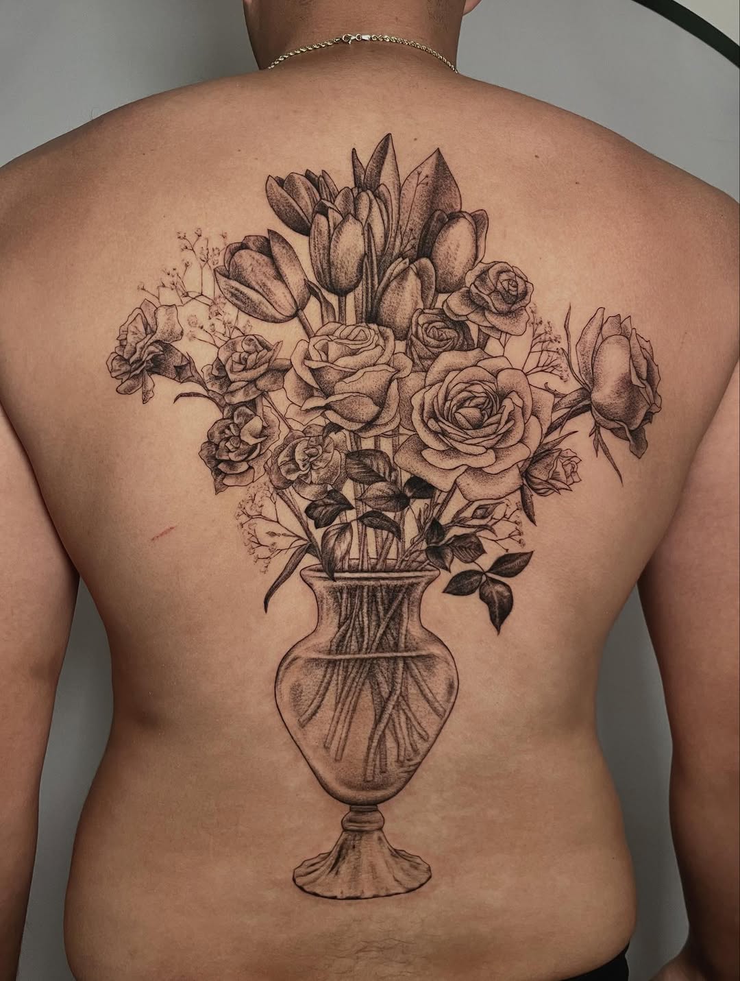 Monochrome bouquet of roses, tulips, carnations, and baby's breath in a vase