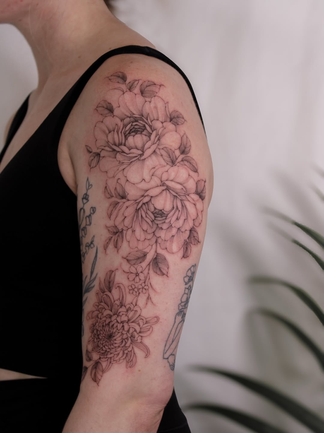Delicate blackwork floral sleeve features peonies and chrysanthemum