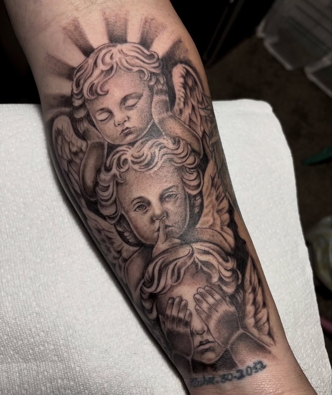 Intricate black-and-gray cherubs with graceful wings