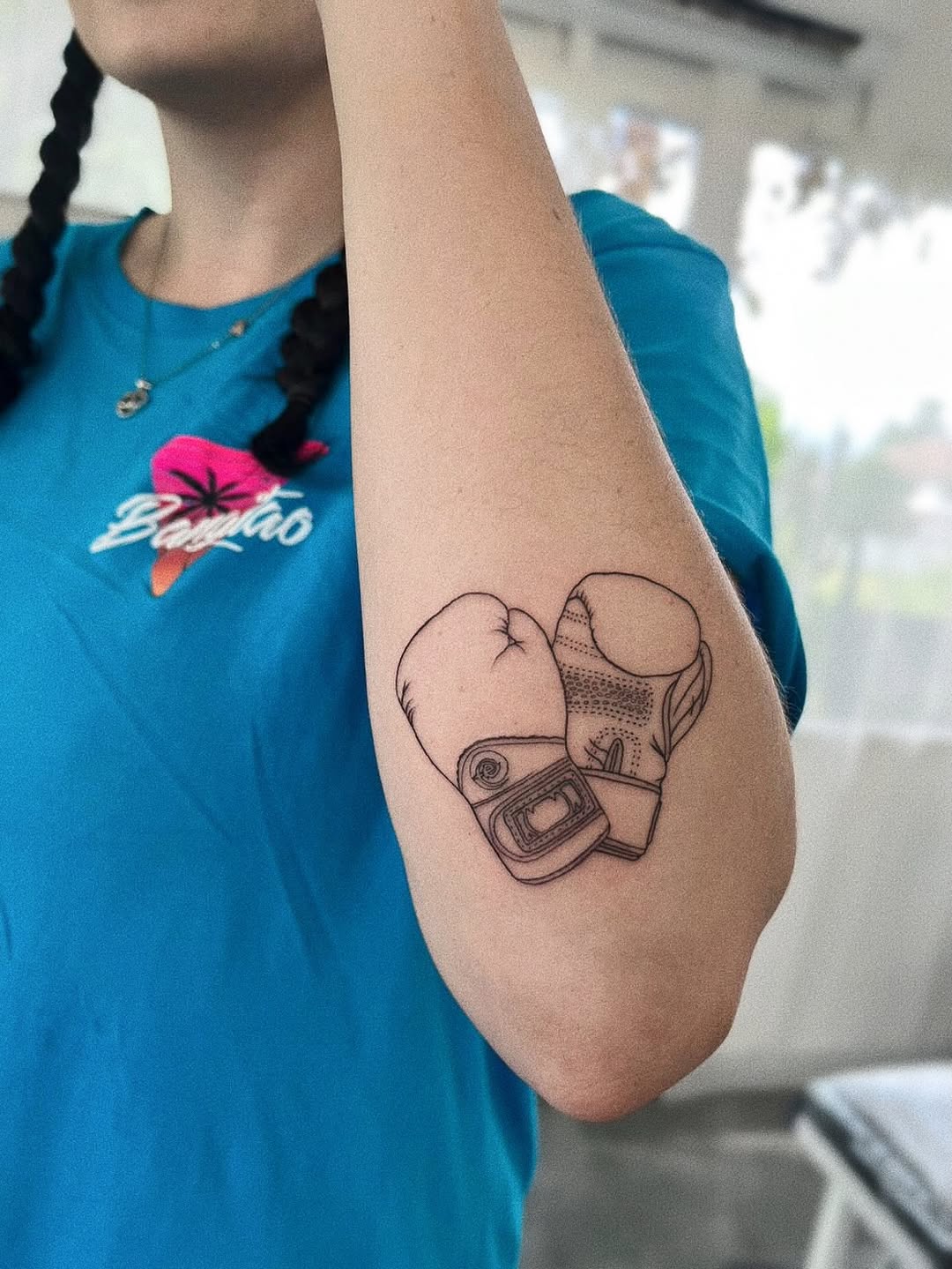 Delicate illustrative boxing gloves in fine-line on inner elbow