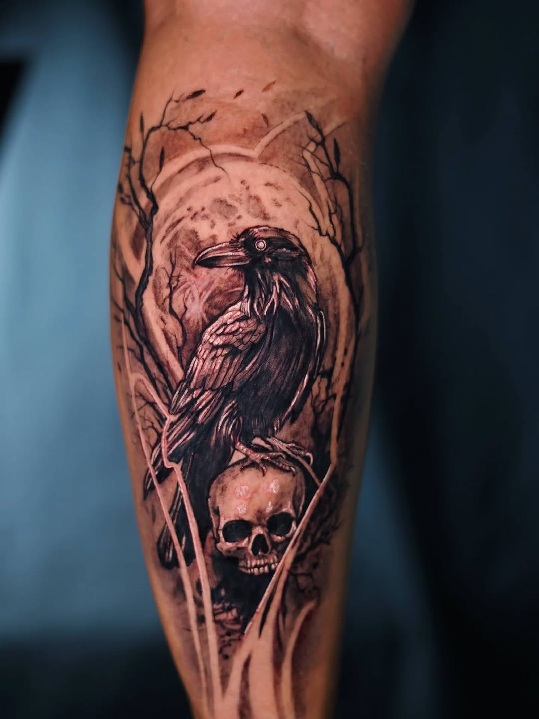 Gothic raven perched above skull with lunar backdrop