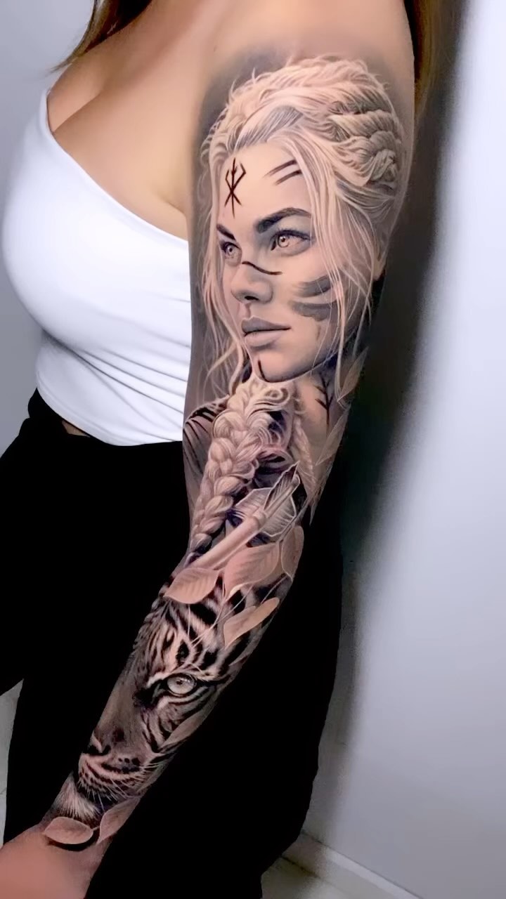 Hyper-realistic grayscale portrait with tiger on inner forearm.