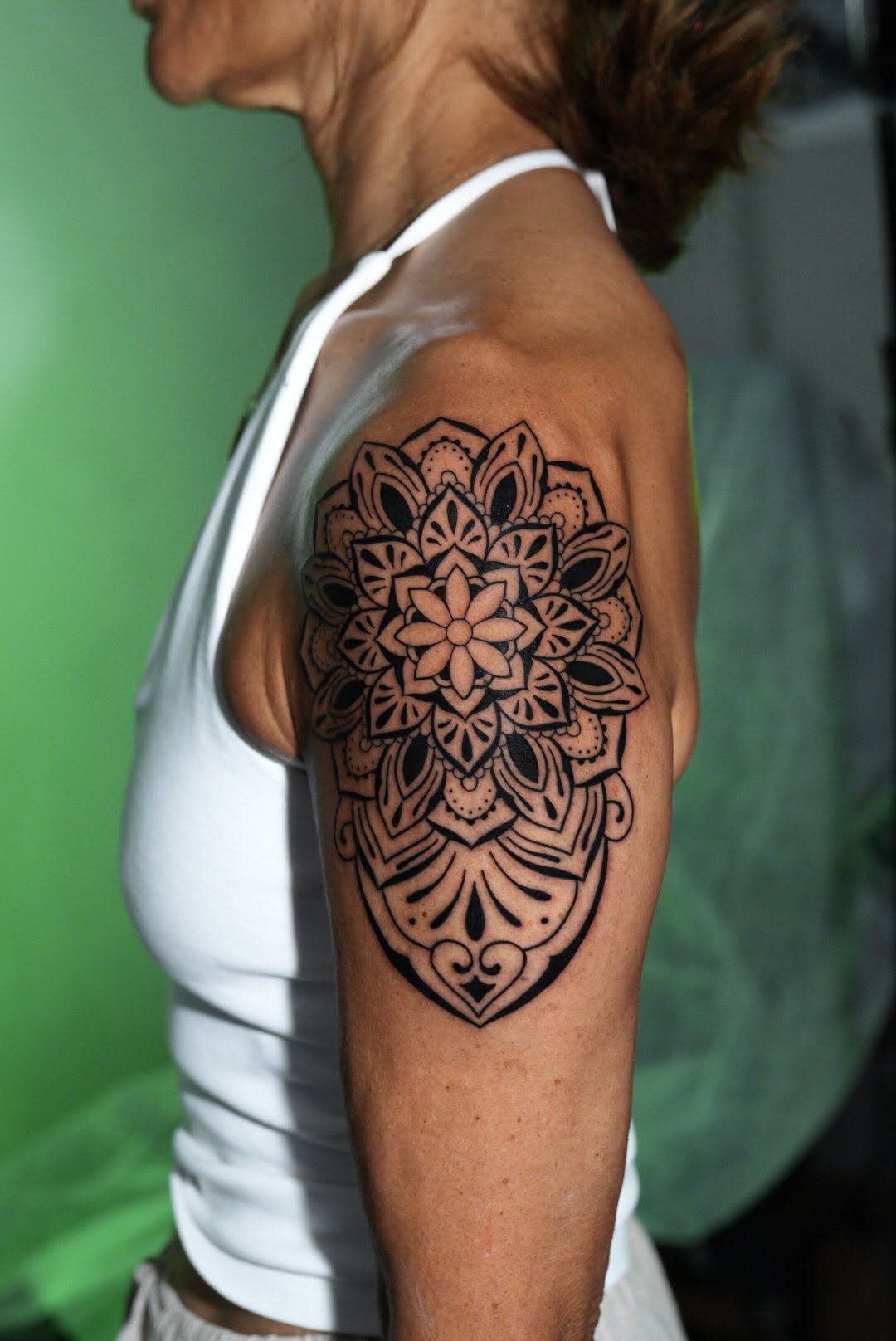 Intricate mandala on upper arm with bold blackwork lines