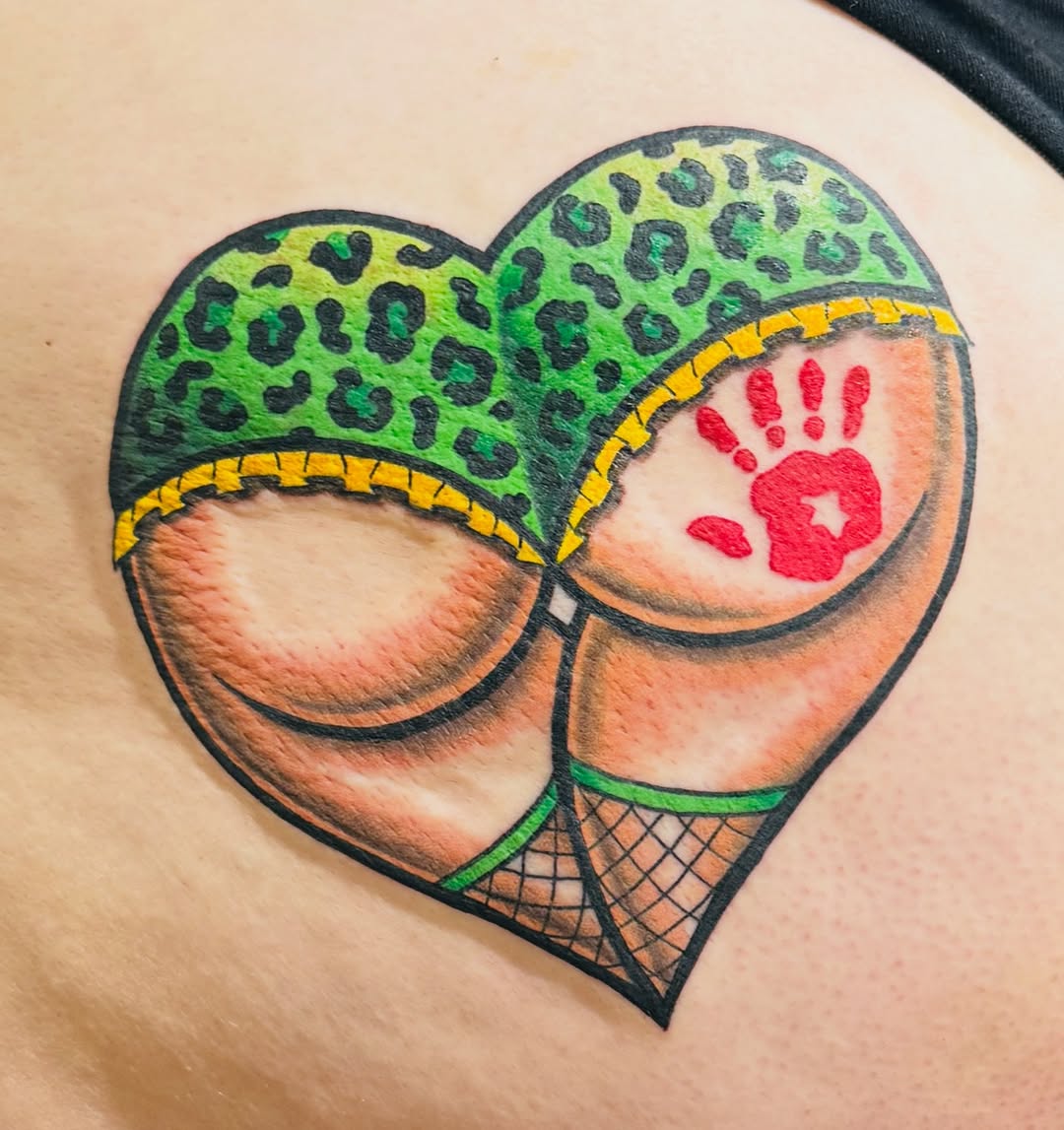Vibrant neo-traditional heart-shaped tattoo with leopard print