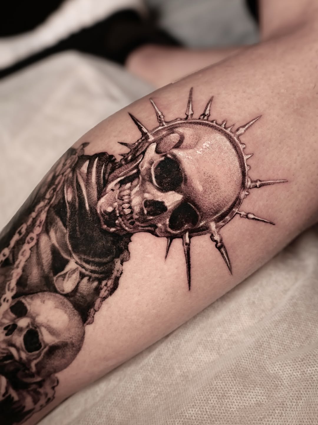 Sunburst halo frames a grim skull with grayscale shading