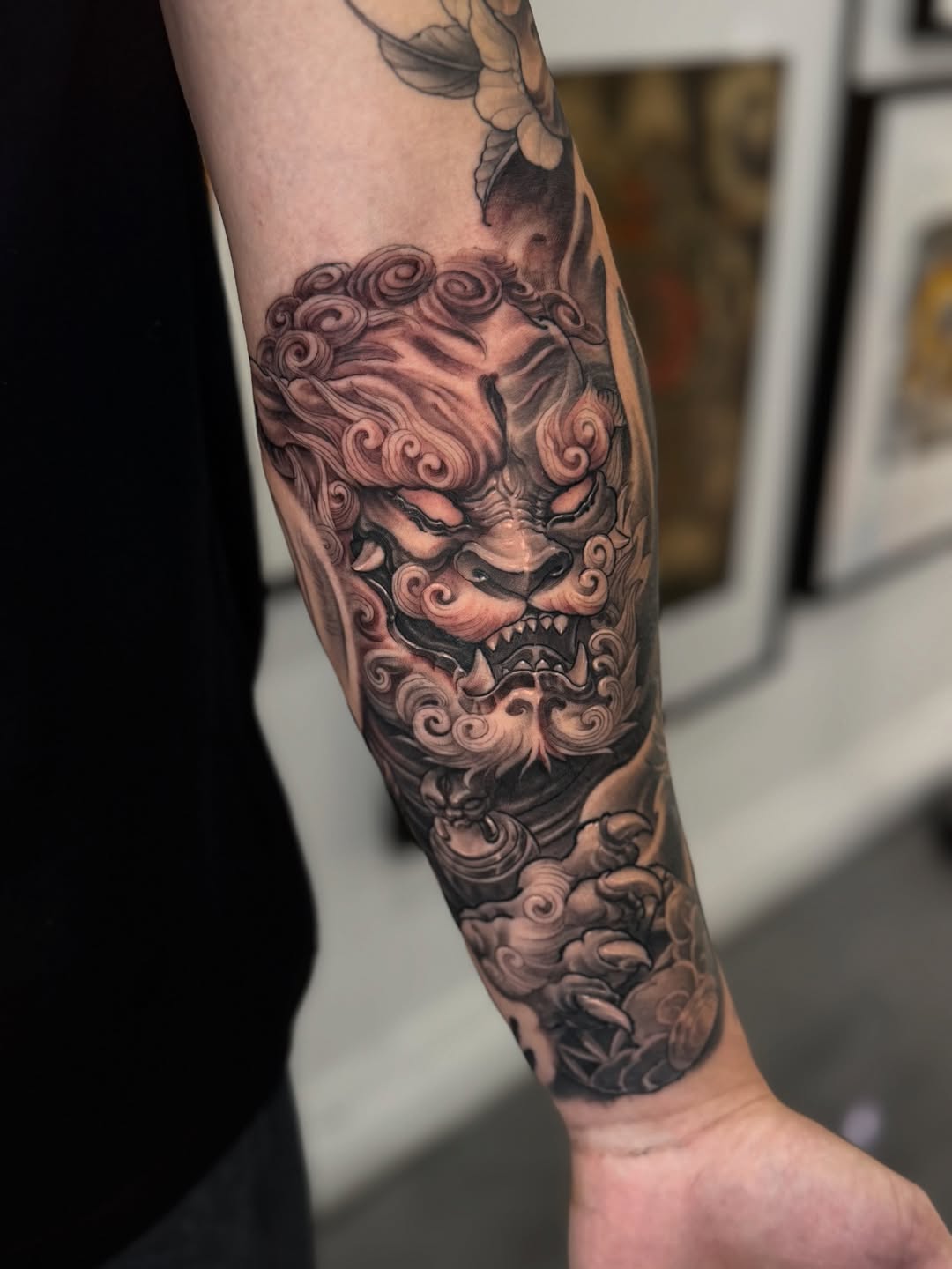 Foo dog with swirling clouds, bold grayscale shading.