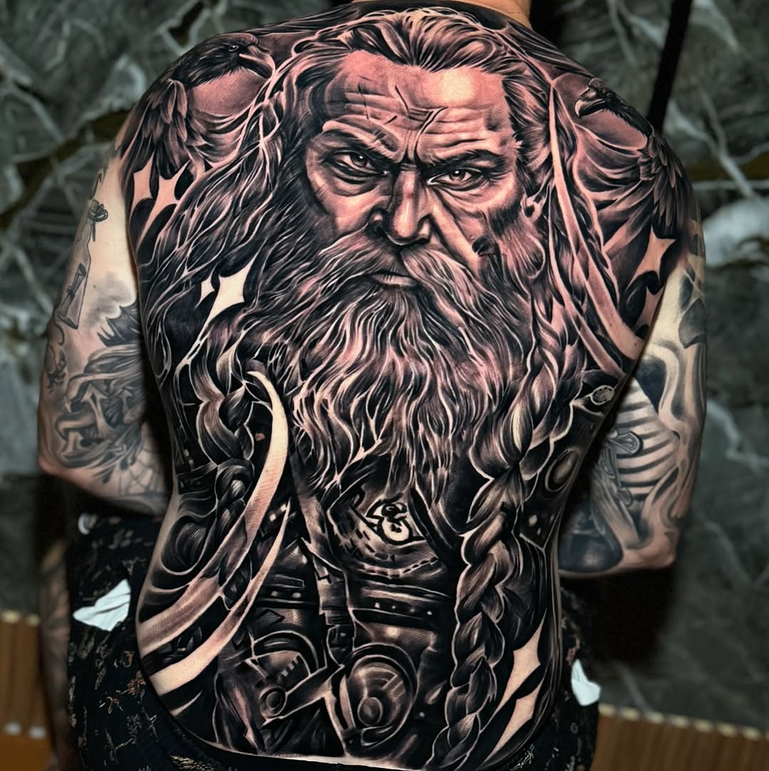 Monumental black-and-gray backpiece of a bearded mythic figure