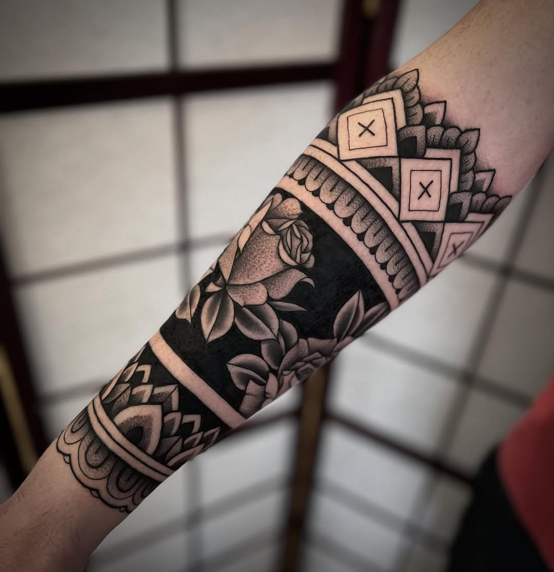 Bold blackwork half-sleeve with geometric patterns and roses