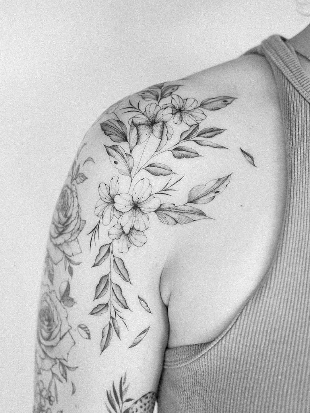 Delicate fine-line floral vine wrapping shoulder and upper arm