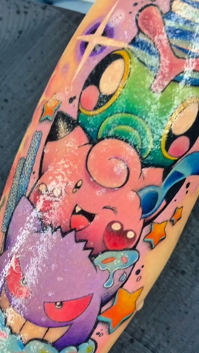 Vibrant cartoon characters forearm tattoo with stars and swirls