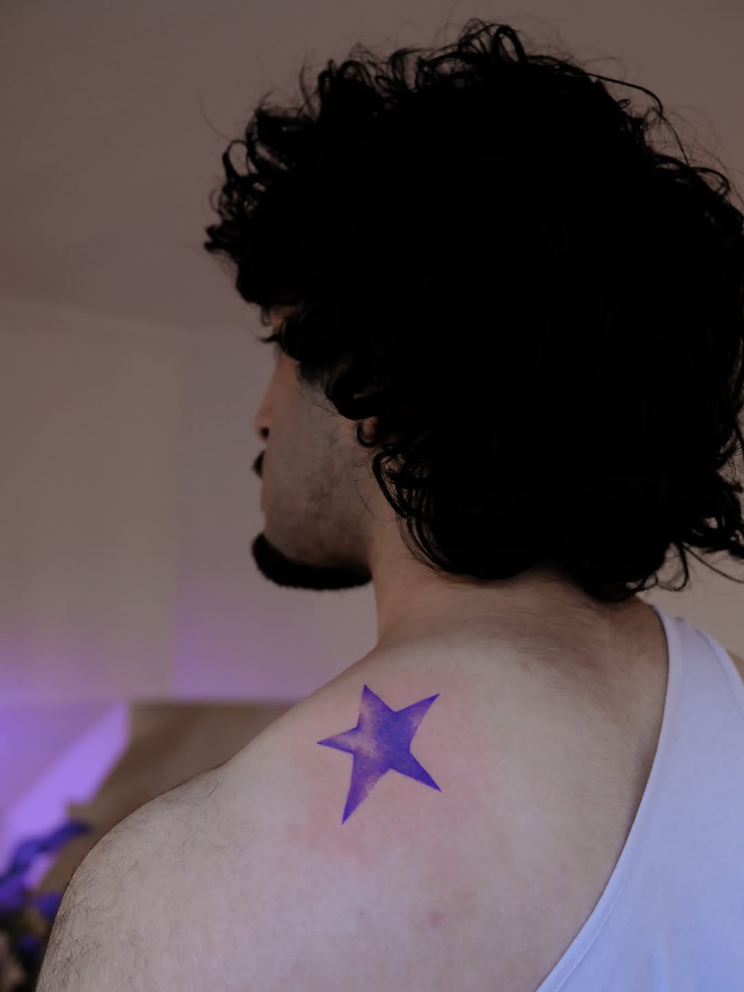 Vibrant purple five-point star on shoulder blade.