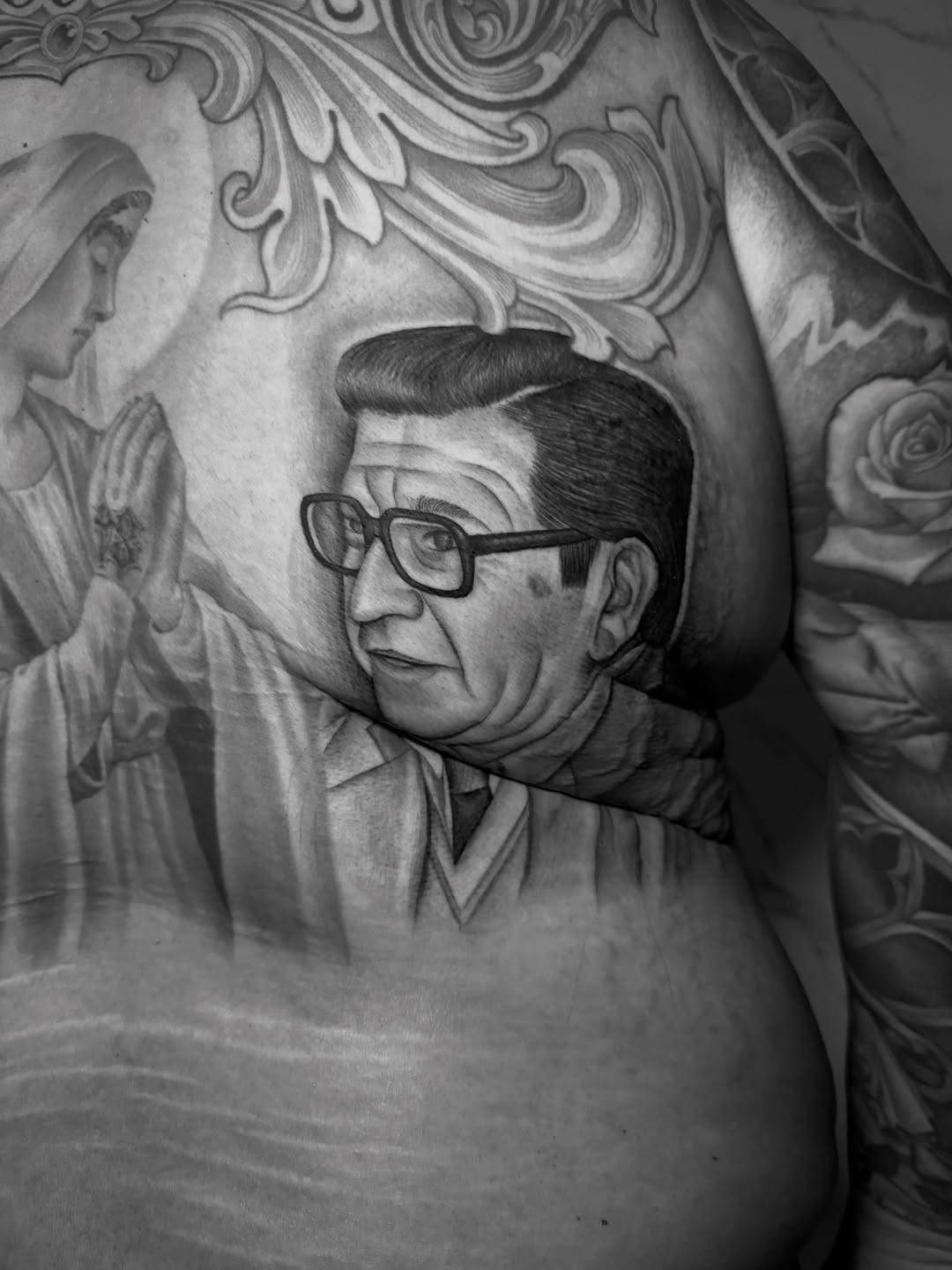 Lifelike grayscale portrait of a bespectacled man.