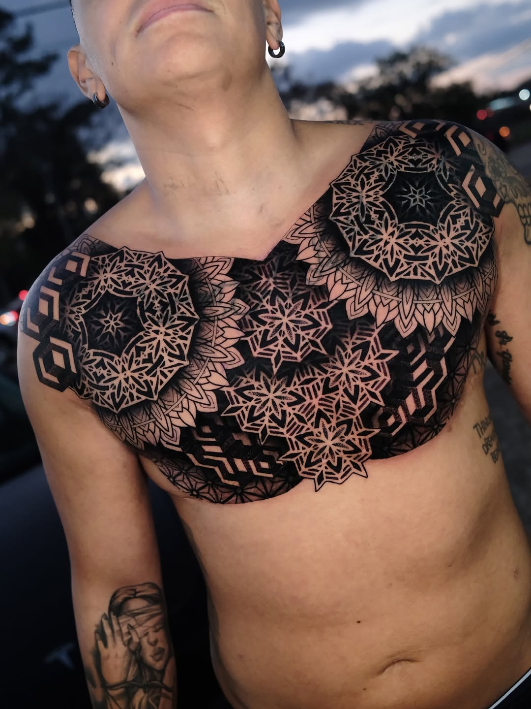 Intricate blackwork geometric mandalas spanning chest and shoulders