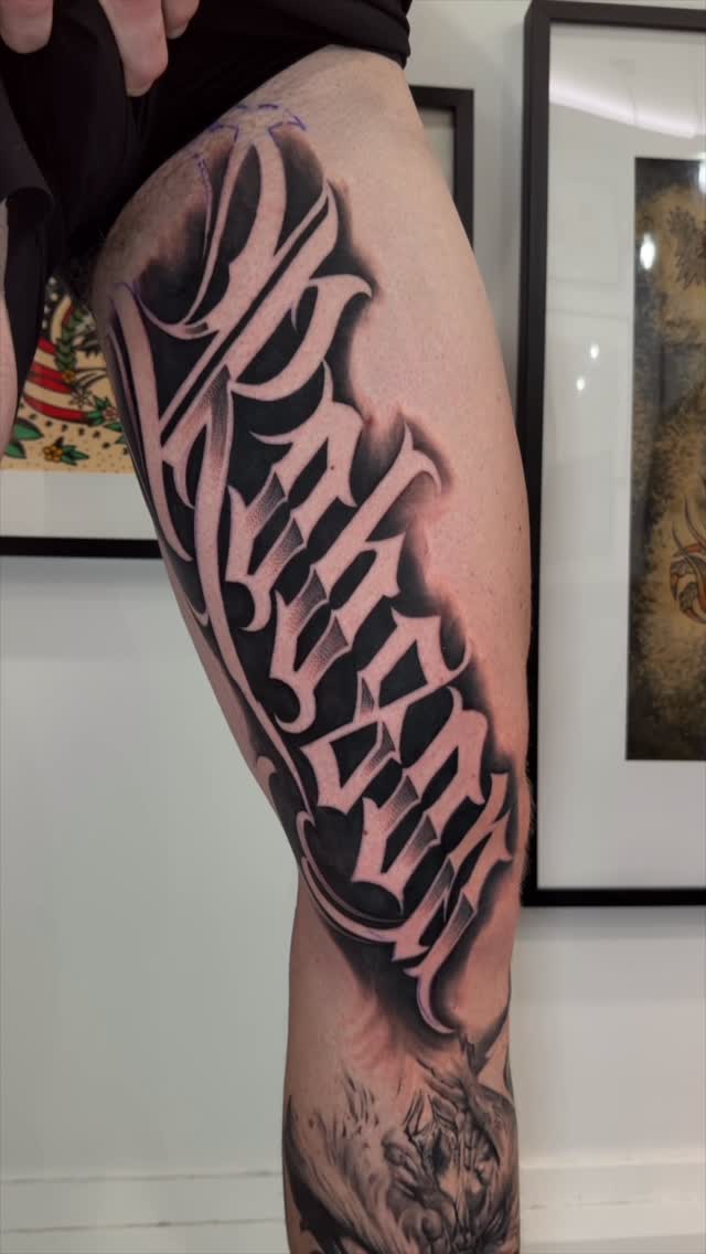 Bold blackletter script leg sleeve with dramatic shading