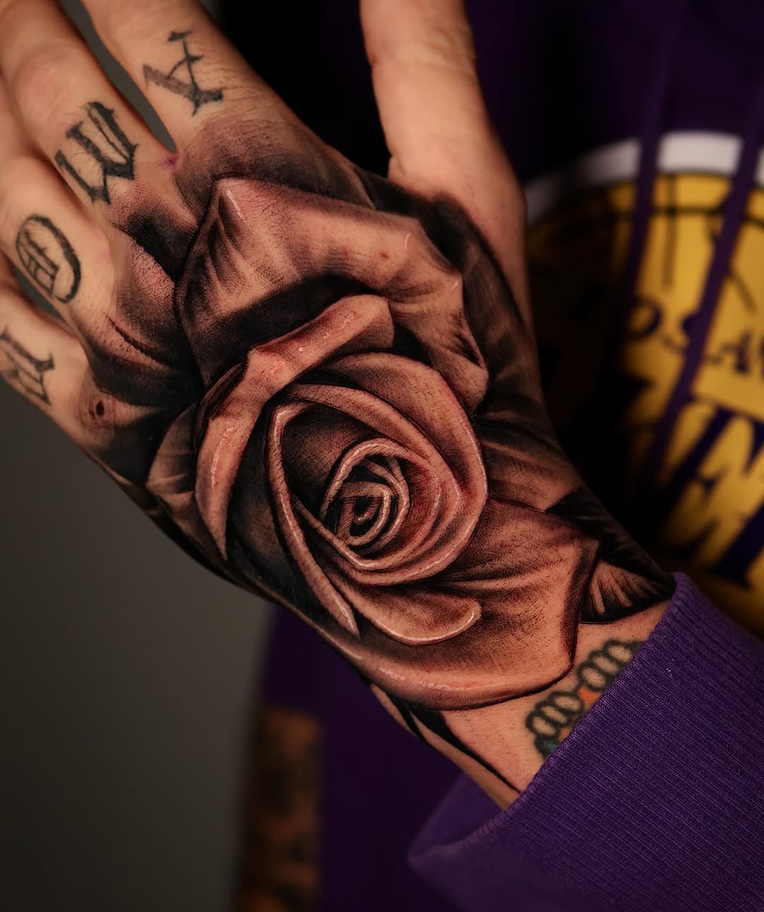 Hyper-realistic grayscale rose forearm tattoo with shading
