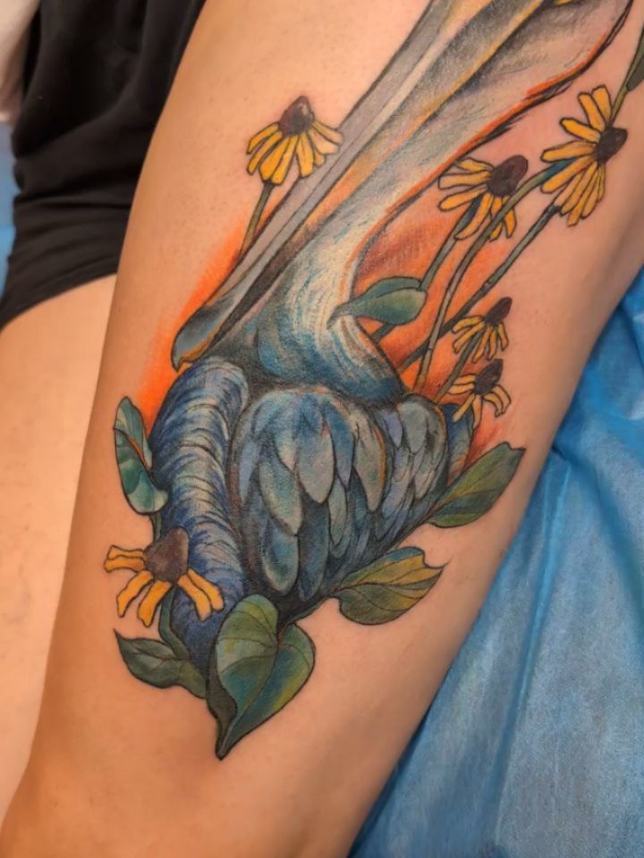 Vibrant watercolor blue bird with yellow daisies and leaves