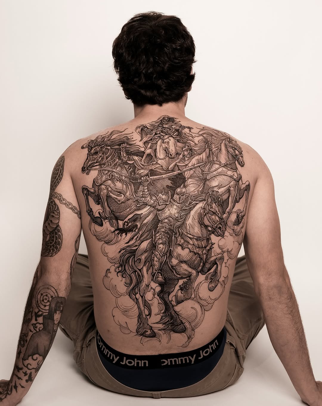 Intricate blackwork back piece of armored horsemen in battle