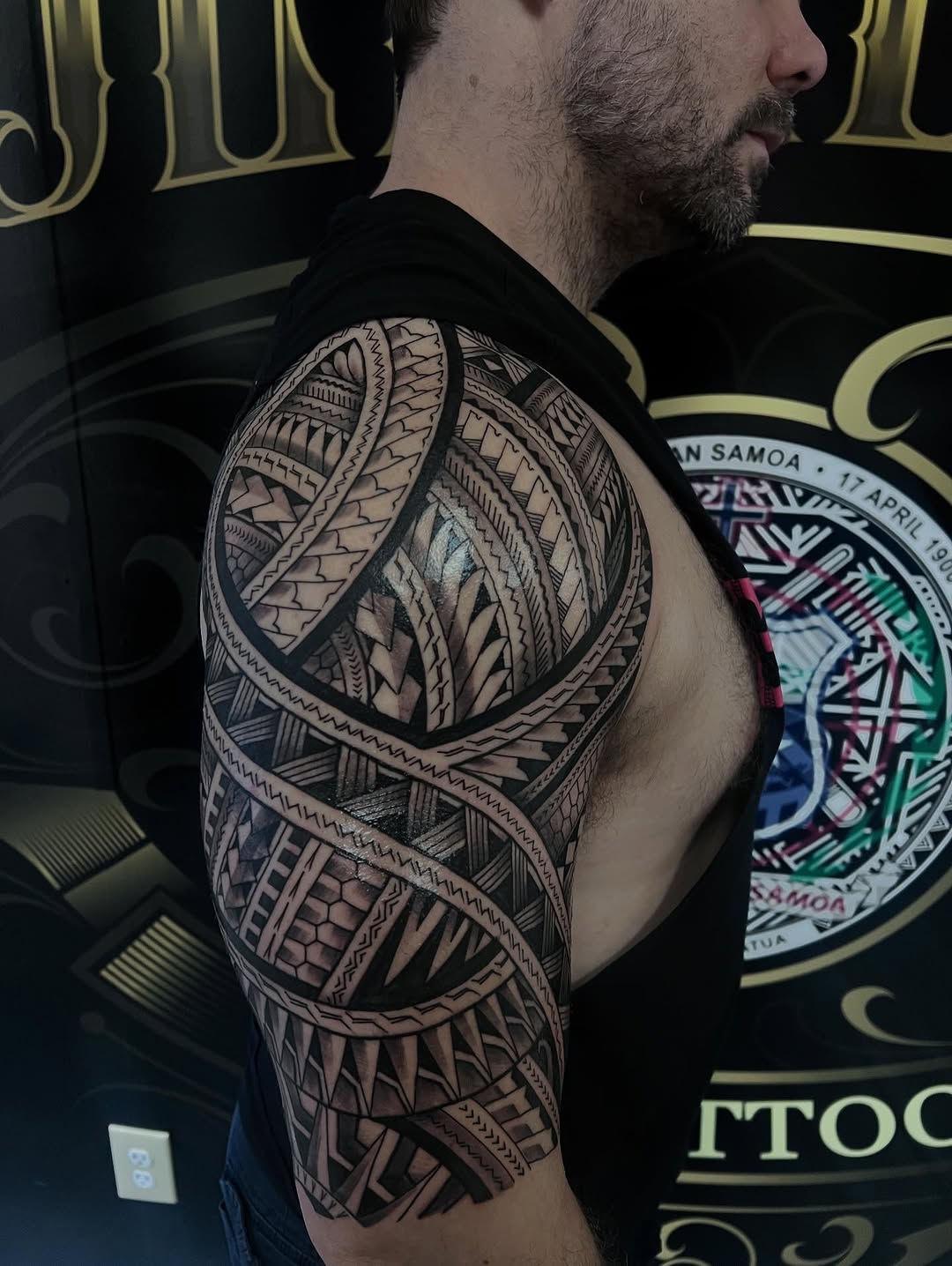 Polynesian-inspired blackwork shoulder half-sleeve with bold motifs