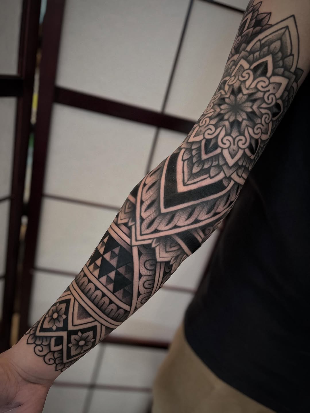 Intricate blackwork forearm sleeve with mandala geometry.
