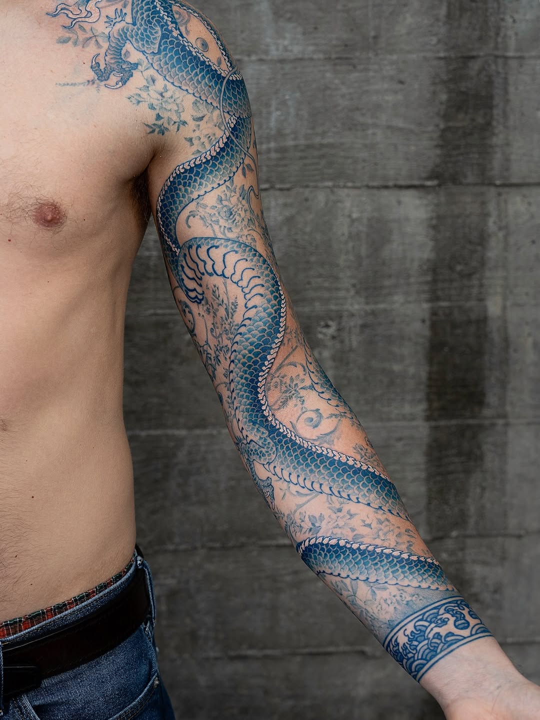 Coiled blue dragon with intricate scales and floral backdrop