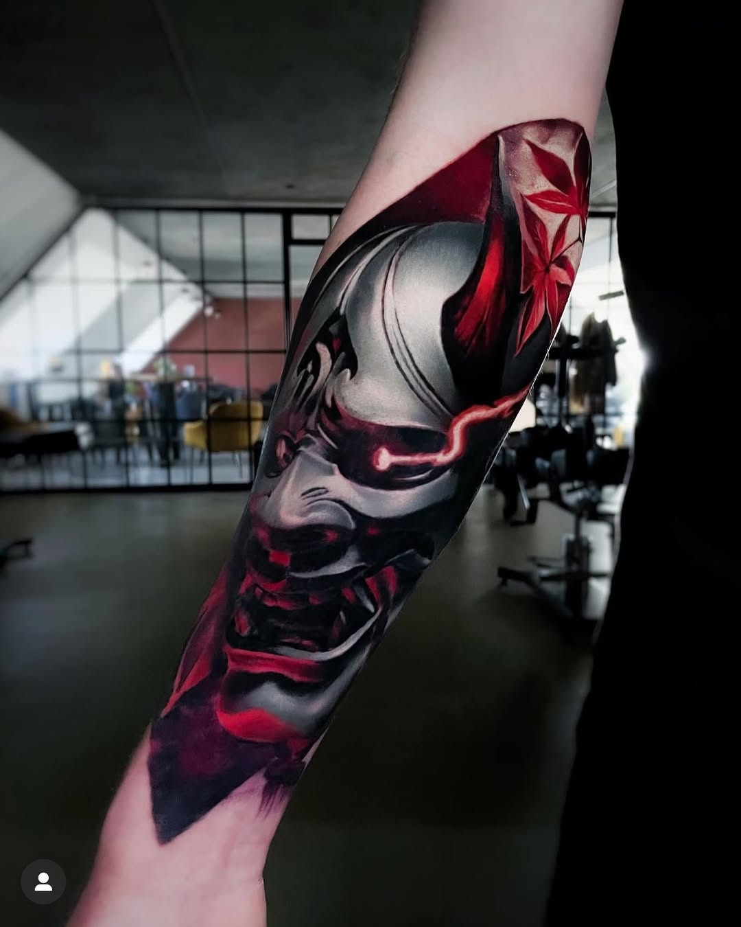 Hyper-detailed black-and-red abstract tattoo on forearm