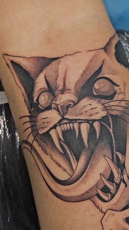 Fierce snarling cat head with bold linework and shading.