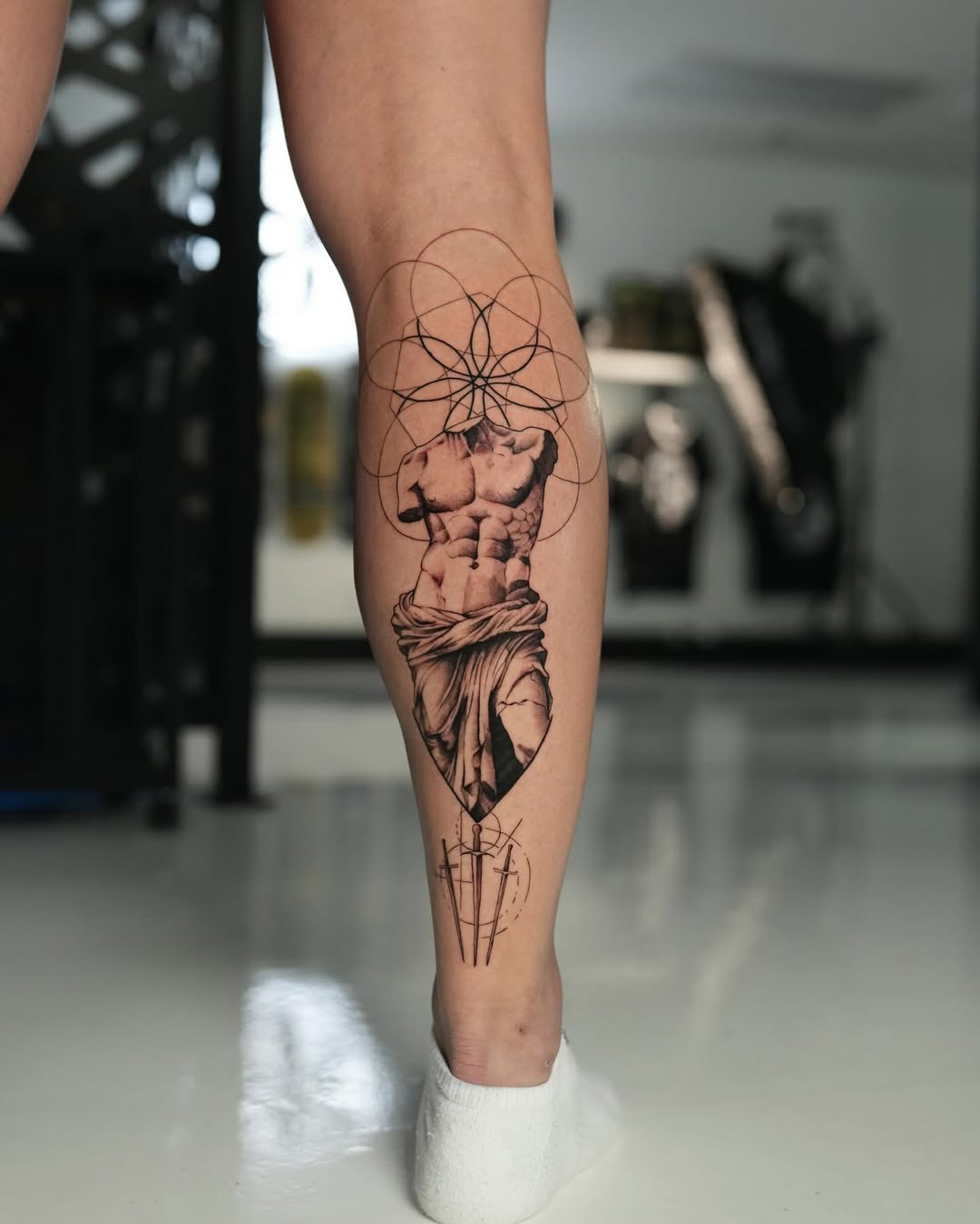 Classical sculpted torso in black-gray realism with geometric halo