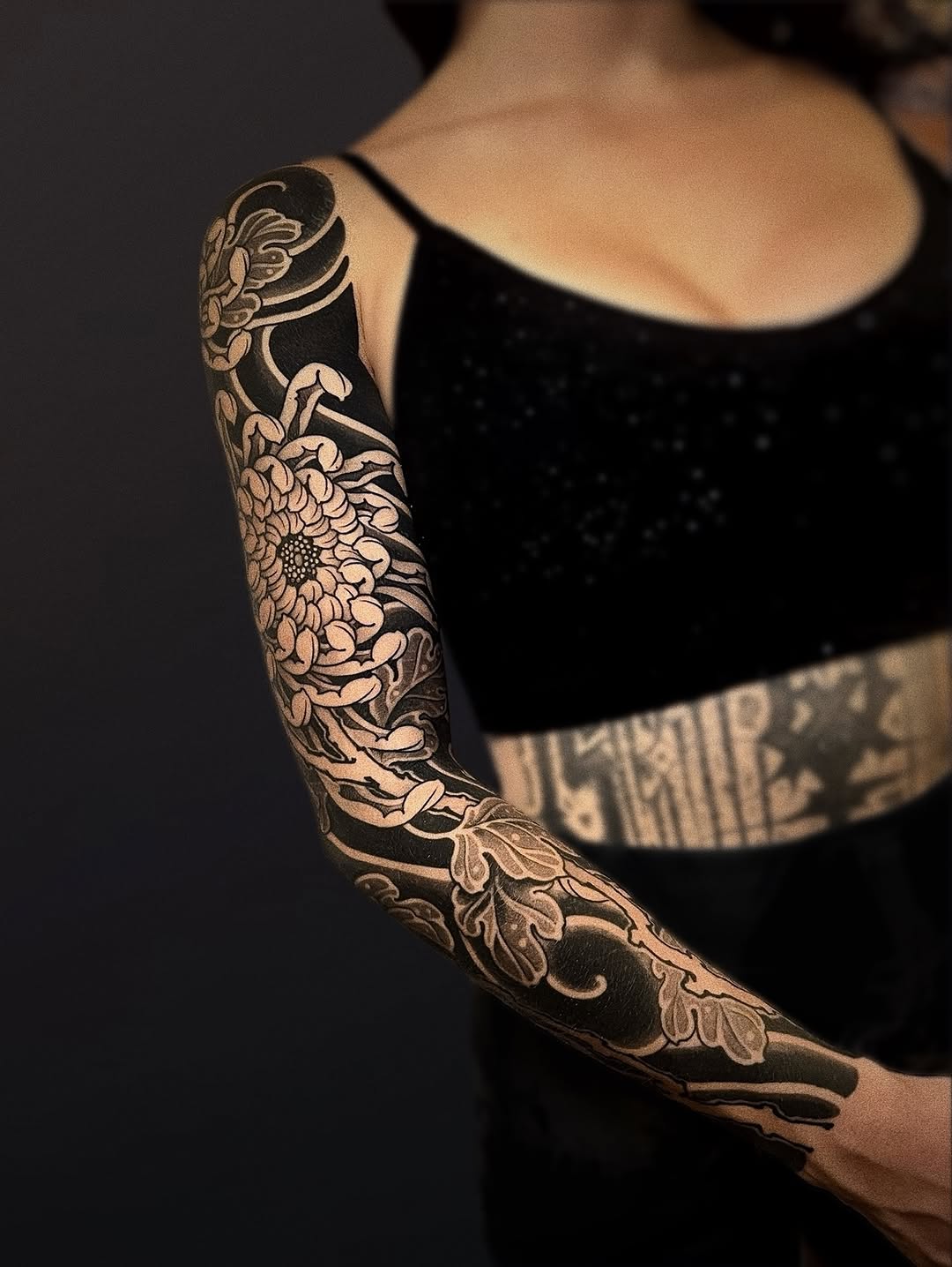 Bold blackwork floral sleeve with intricate petals and vines.