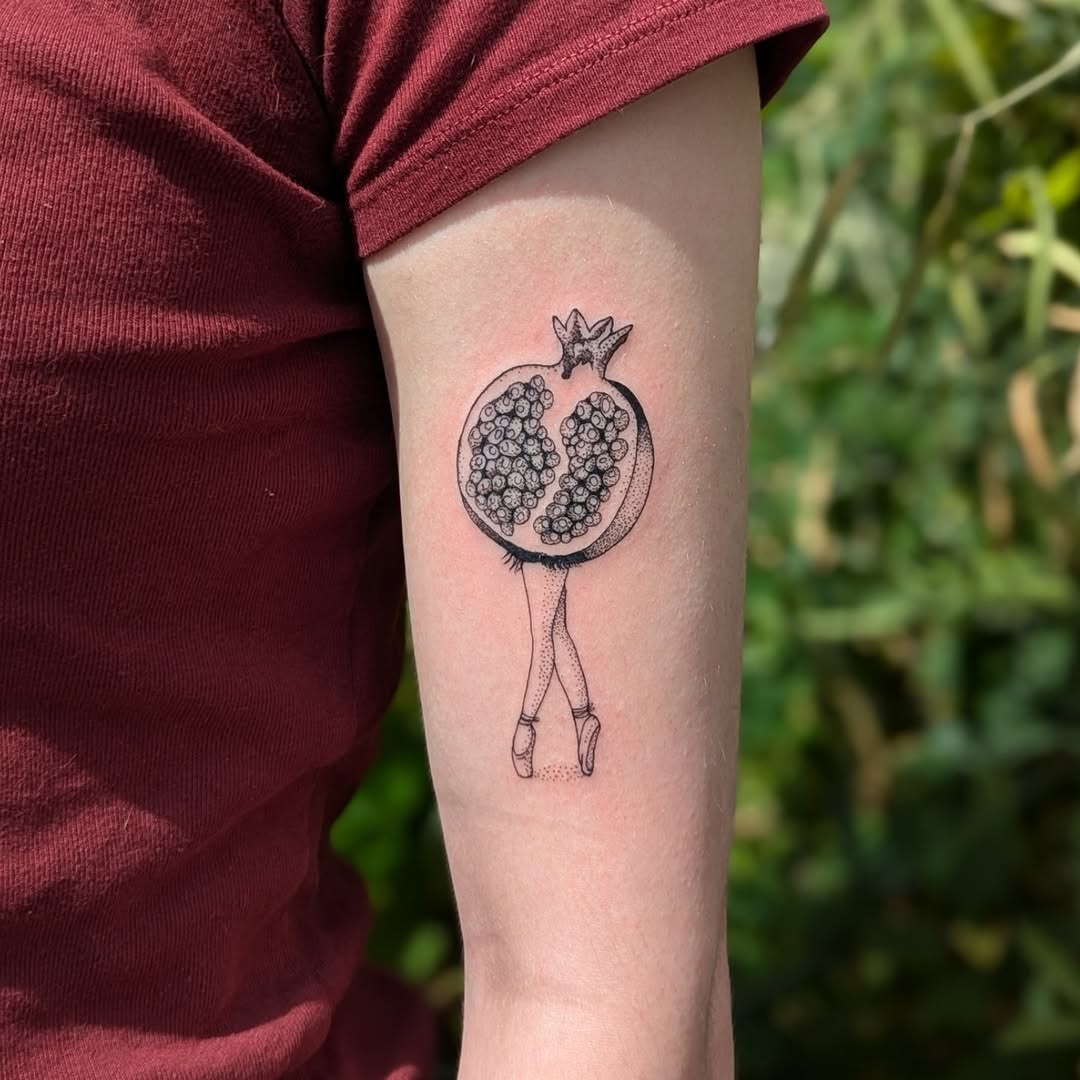 Delicate fine-line pomegranate ballerina on inner forearm.