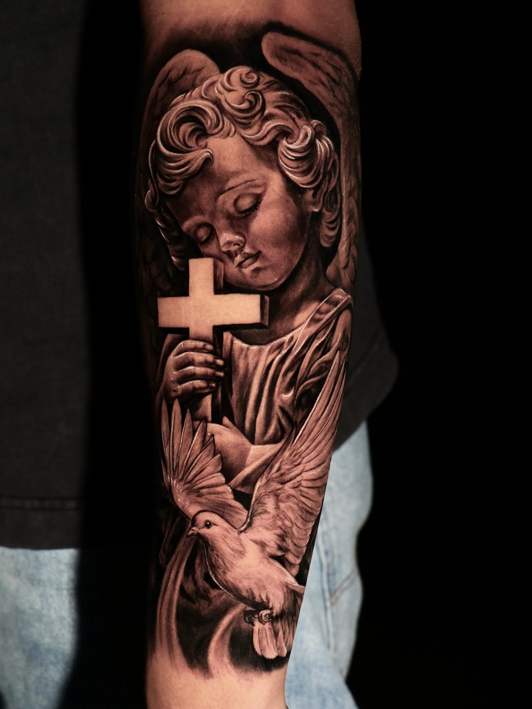Dark-gray cherub portrait with cross and dove