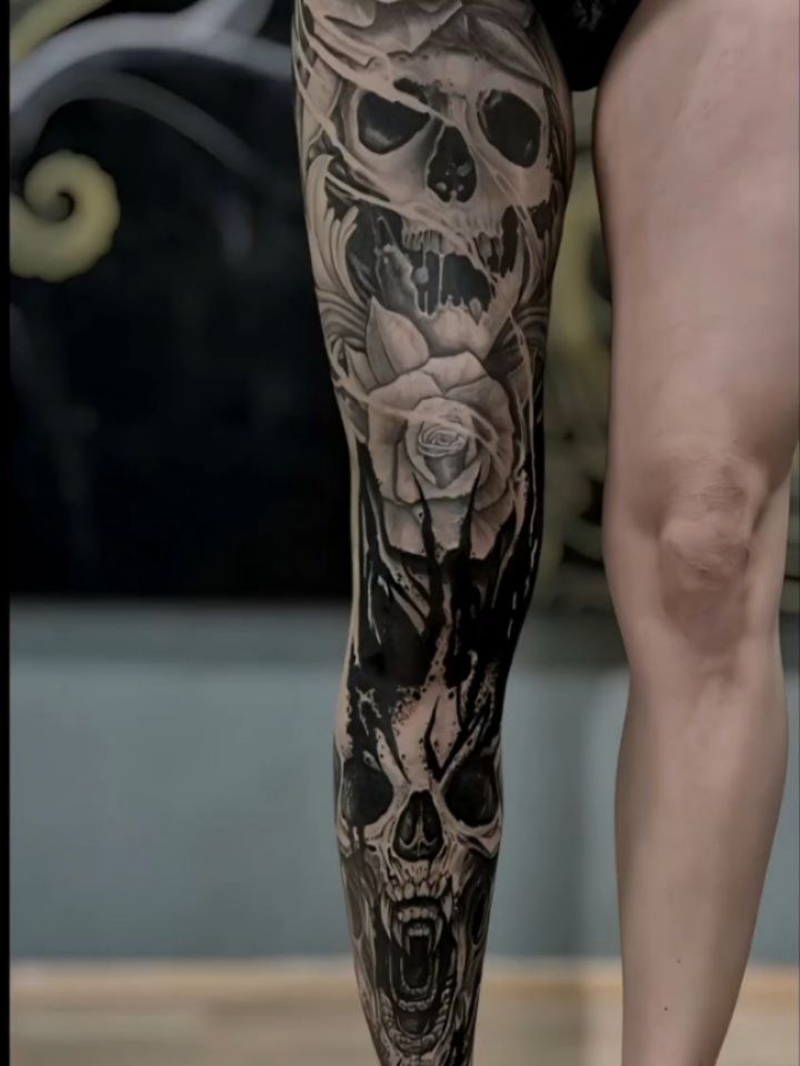 High-contrast blackwork leg sleeve with skulls and roses.
