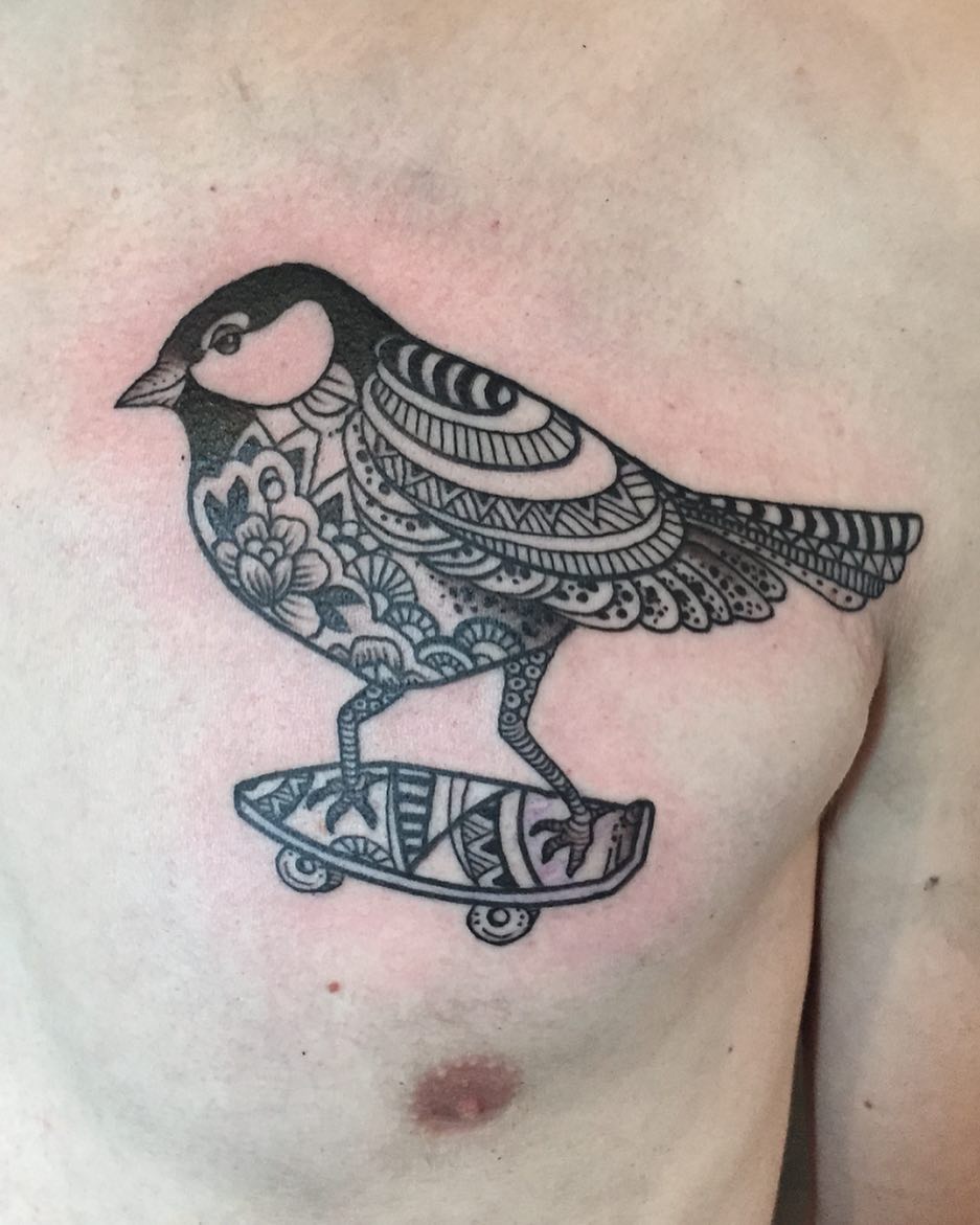 Intricate blackwork bird on a skateboard with ornate patterns.