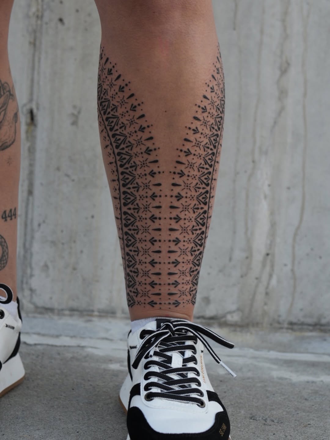 Intricate geometric dotwork leg pattern with bold linework