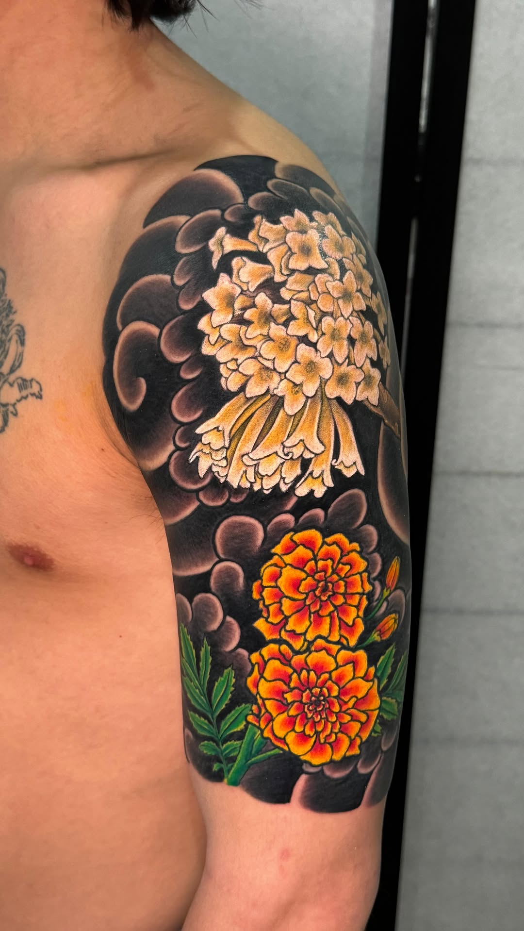 Vibrant Japanese floral motif on upper arm, bold petals