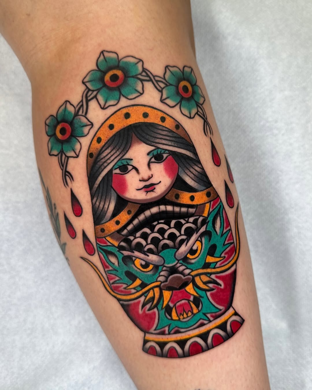 Colorful Matryoshka doll tattoo with floral crown and dragon