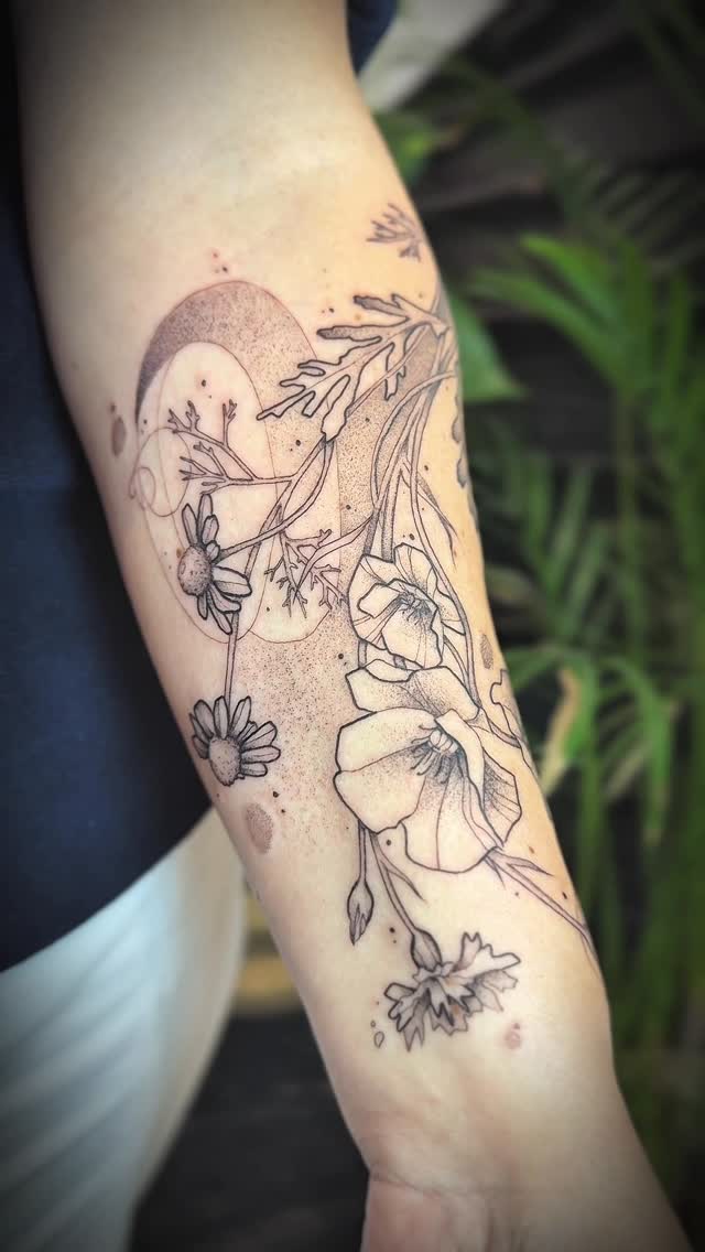 Delicate botanical linework with daisy-like blooms and crescent moon on forearm
