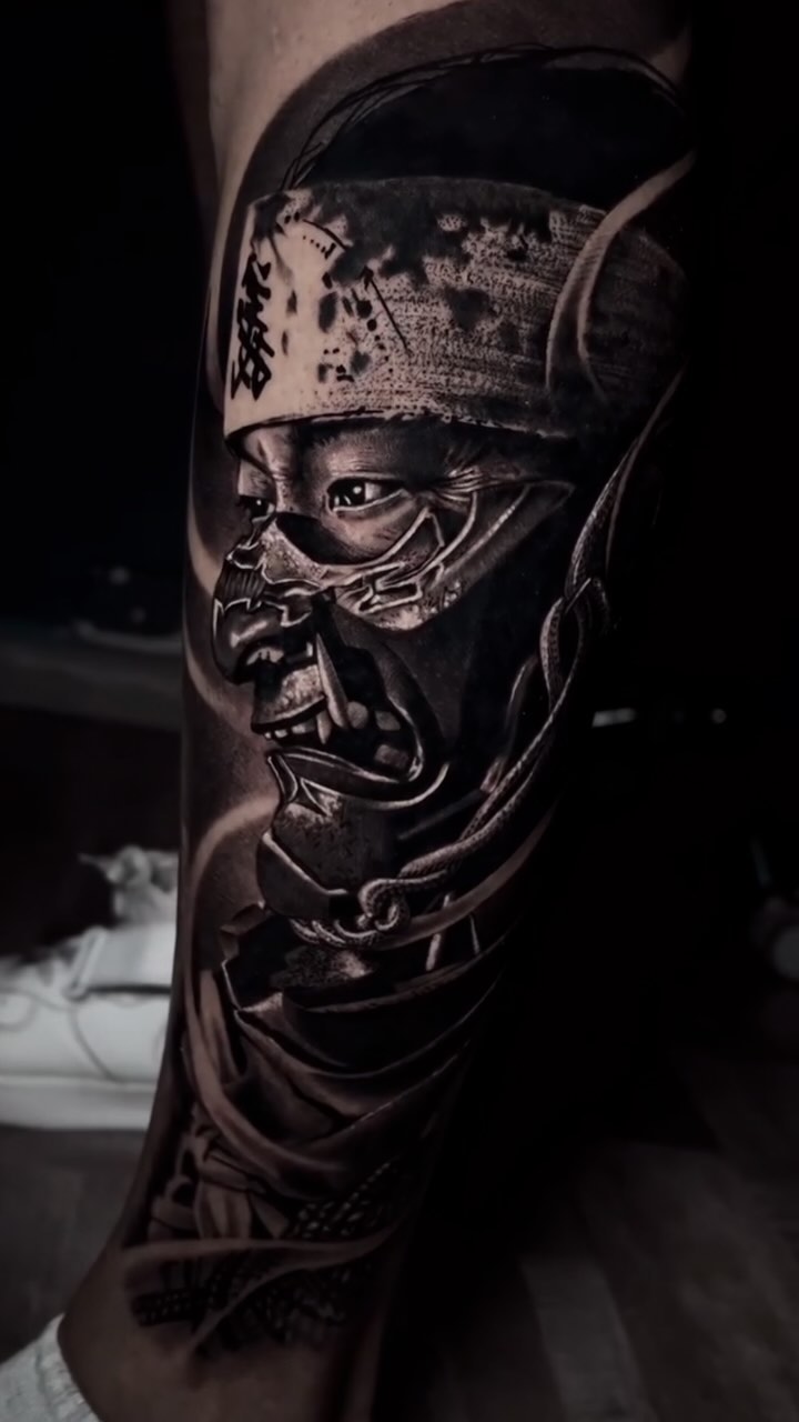 Hyper-detailed black-and-gray samurai portrait on calf