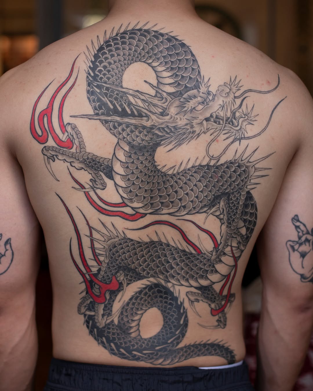 Majestic black-and-gray dragon backpiece with red accents